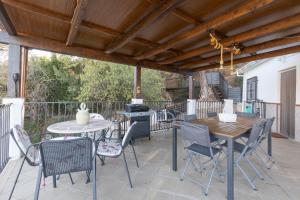 a patio with a table and chairs and a grill at Paraje fuente del pintor in Iznalloz