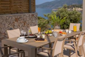 a table with food on it with a view of the water at Villa Armiriki-Private Sea Access in Évyiros