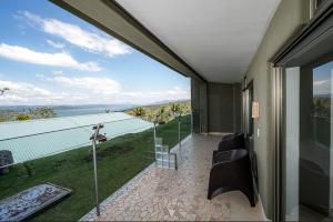 a room with a balcony with a view of the water at Lake Arenal Condos in Naranjos Agrios