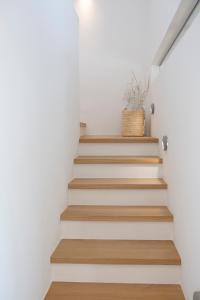 a staircase in a house with white walls and wooden floors at Villa Armiriki-Private Sea Access in Évyiros +38 photos