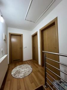 an empty room with two doors and a rug at SA Apartment in Sarajevo