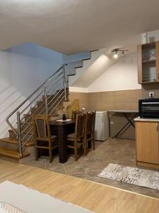a kitchen with a table and chairs and a staircase at SA Apartment in Sarajevo