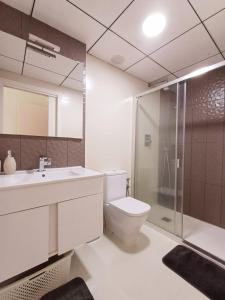 a bathroom with a toilet and a sink and a shower at Умные новые аппартаменты в Торревьехе in Torrevieja