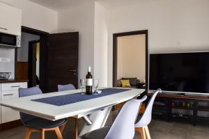 a kitchen and dining room with a white table and chairs at Apartmani Čeko in Selce