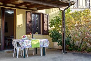 un tavolo e sedie sotto un pergolato su un patio di Villa Comi a Giurdignano