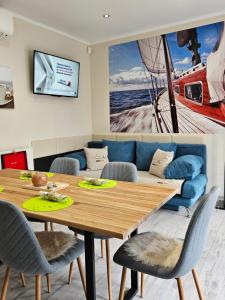 - une salle à manger avec une table et un canapé dans l'établissement Bowery Guest Houses - Árnyas vendégházak, à Balatonalmádi