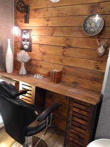 eine Holzwand mit einem Schreibtisch und einem schwarzen Stuhl in der Unterkunft Chimay Welcome in Chimay