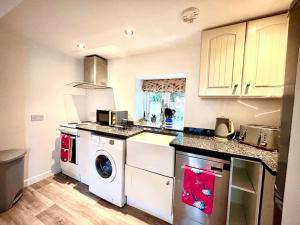 a kitchen with a washer and dryer in it at The Barn by MaisonPro in Cam