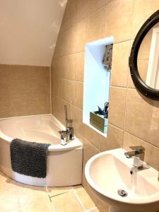 a bathroom with a bath tub and a sink at The Barn in Cam