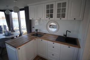 Modernes festliegendes Hausboot mit großzügiger Dachterrasse und Ruderboot的厨房或小厨房