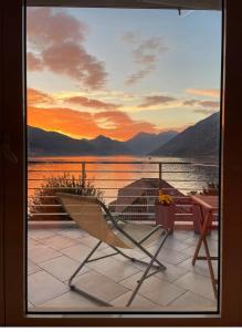 een boot op een veranda met uitzicht op het water bij Sea View Apartment Ljuta in Kotor