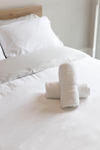two rolled up towels on a white bed at DWTN Condo Near CN Tower! w/ Free Parking in Toronto