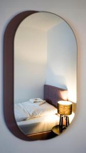 een spiegel die een slaapkamer met een bed en een tafel weerspiegelt bij SI-View Einzelzimmer Zimmer 11 in Siegen