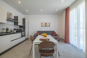 a kitchen and living room with a table and chairs at Case Vacanza Loria in Castelluzzo