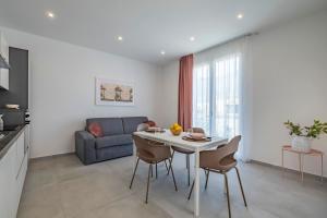 a kitchen and living room with a table and a couch at Case Vacanza Loria in Castelluzzo
