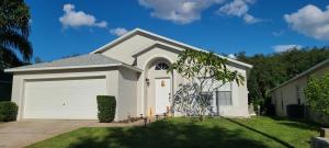 een kleine witte garage met een boom in de tuin bij Home Close to Disney Parks/Amazing Private Pool in Orlando