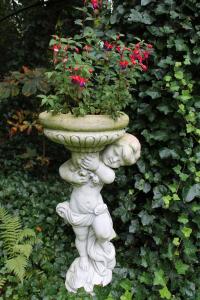 a white stone planter with red flowers in it at Boutique Hotel Rosengarten Hamburg in Hamburg