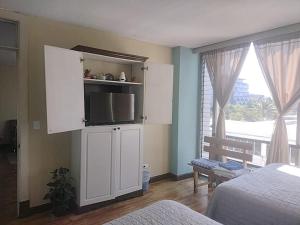 a bedroom with a white cabinet with a flat screen tv at Apartamento 505 Cortijo Reforma zona 9 in Guatemala