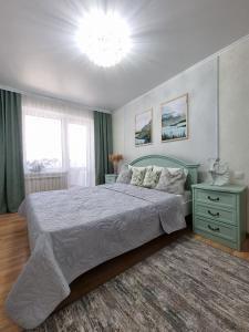 a bedroom with a large bed and a chandelier at Идеальная 4-х комн, с домашним уютом и простором in Kostanay