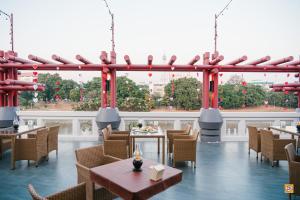 a restaurant with tables and chairs and a large window at Wangchan Riverview in Phitsanulok