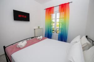 Schlafzimmer mit einem Bett und einem Regenbogenfenster in der Unterkunft Ionian Luxury Apartments in Perama