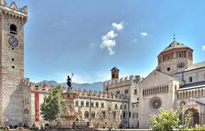 a large stone building with a statue in front of it at Appartamenti ClesioResidenceBuonconsiglio in Trento