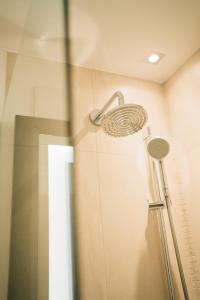 a shower with a shower head in a bathroom at Klostermaier Hotel & Restaurant in Icking