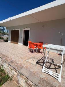 une table et des chaises assises sur une terrasse dans l'établissement Great Escape Ksamil, à Ksamil