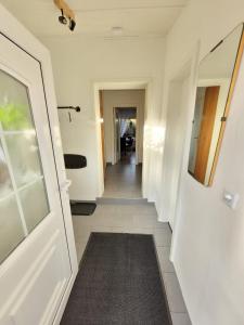 a hallway with a white door and a tile floor at Donner in Hollenstedt