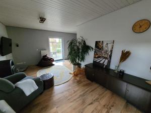 ein Wohnzimmer mit einer Couch und einer Uhr an der Wand in der Unterkunft Donner in Hollenstedt + 27 Fotos