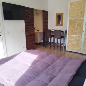 Un dormitorio con una cama grande y una mesa con sillas. en Garibaldi Guest House, en Macerata