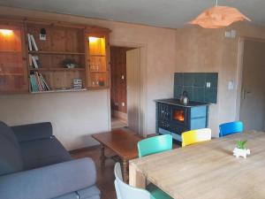a living room with a table and chairs and a stove at Centre de vacances NatUrsanne in Saint-Ursanne