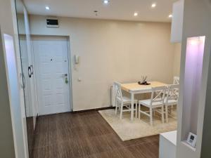 ein Esszimmer mit einem Tisch und weißen Stühlen in der Unterkunft Luxury Large Family Apartment in Zalău