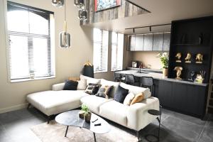 sala de estar con sofá blanco y cocina en SUBSTANTIEL - Luxury Rooms & Wellness Suite en Brunehaut