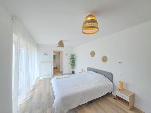 a white bedroom with a large bed and a potted plant at Moscou, Grande Maison proche Reims in Berru