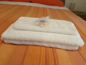 una pila de toallas blancas en una cama en Villa Maria, en Marina di Ravenna