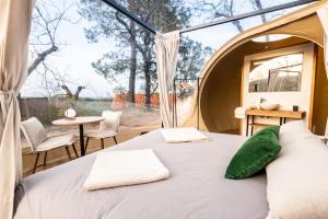 a bedroom in a tent with a bed and a table at Horizonte Bubble rooms in Cortegana