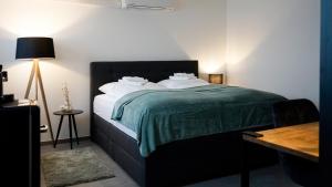 ein Schlafzimmer mit einem Bett mit einer grünen Decke und einem Schreibtisch in der Unterkunft Si-View Doppelzimmer Zimmer 14 in Siegen