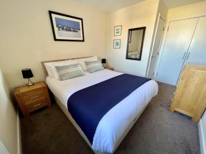 a bedroom with a large bed with blue and white sheets at Lovely 2 Bedroom flat moments from Fistral Newquay in Newquay