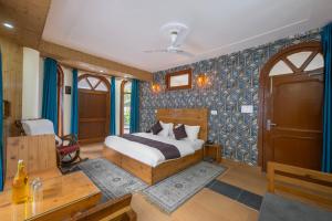 a bedroom with a king sized bed and a desk at Calm Cottage KASAULI HILLS Barog in Barog