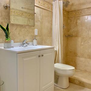 y baño con lavabo blanco y aseo. en Gorgeous Rooms in Miramar Prestigious State Home - Min 31 Days Rental, en Miramar