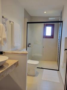 a bathroom with a shower and a toilet and a sink at Arandu Sagi Inn in Baía Formosa