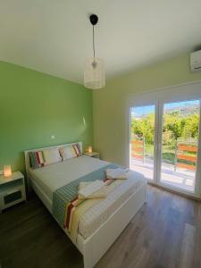a bedroom with a bed and a large window at Ktima Klimentini in Vivari