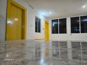 a room with a concrete floor and a yellow door at The Ortus Stays -The Sunset Room in Orchha