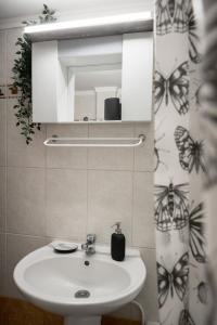 een badkamer met een wastafel en een spiegel bij Peraia Deluxe Apartment in Perea
