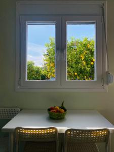 a table with a bowl of fruit in front of a window at Ktima Klimentini in Vivari