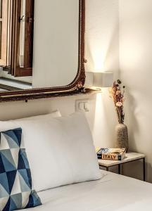 espejo en la pared sobre una cama con almohada en MAYA RHOME TRASTEVERE, en Roma