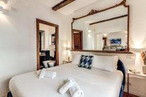 1 dormitorio con cama blanca y espejo grande en MAYA RHOME TRASTEVERE en Roma