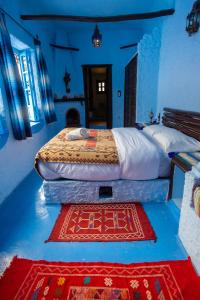 a bedroom with two beds and a rug on the floor at Dar Dadicilef in Chefchaouen