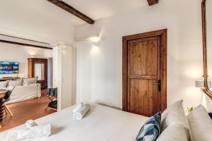 Habitación con cama blanca y puerta de madera. en MAYA RHOME TRASTEVERE, en Roma